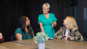 Three members of staff from Thrive Law, stood and sat around a table deep in discussion.